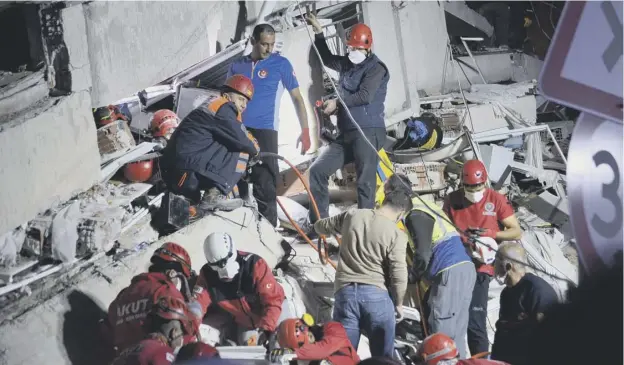  ??  ?? 0 Rescuers search for survivors at a collapsed building after a powerful earthquake struck Turkey’s western coast and parts of Greece