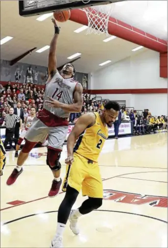  ?? JOHN BLAINE — FOR THE TRENTONIAN ?? Rider’s Dimencio Vaughn (14) lays the ball in for a basket as Canisius’ Jermaine Crumpton (2) defends during a MAAC game on Sunday afternoon.