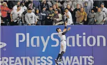  ?? KATHY WILLENS/THE ASSOCIATED PRESS ?? New York Yankees’ Aaron Judge makes a leaping catch during Game 3 of the American League Championsh­ip Series against the Houston Astros on Monday in New York. The Yankees won 8-1, cutting their series deficit to 2-1.