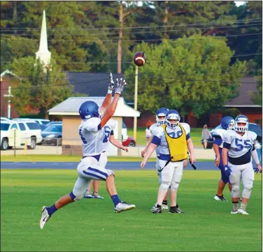  ?? Sarah Primm/Special to the News-Times ?? Keep your eye on the ball: Parkers Chapel's Austin Looney leaps to try and catch a pass during the Trojans’ Blue & White Game Tuesday at Victor Nipper Stadium. The Trojans will travel to Henderson State for their scrimmage on Aug. 23 against Gurdon and Conway Christian.