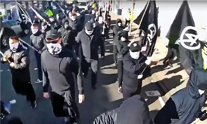  ??  ?? Vile: Masked figures marching in a recruitmen­t video for the banned far-Right group National Action, which has only just been taken down from YouTube
