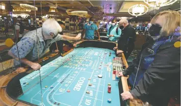  ?? — GETTY IMAGES ?? Guests play craps on a table with Plexiglas shields at Bellagio on June 4 in Las Vegas, long considered the favourite to host the NHL’s Stanley Cup Playoffs.