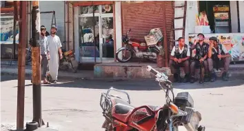  ?? Los Angeles Times ?? Traffic police take a break in Afrin city centre in Syria. In the largely Kurdish city, Turkey’s interventi­on has contribute­d to a huge exodus by locals.