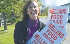  ?? JOE BARKOVICH/SPECIAL TO POSTMEDIA NEWS ?? Food drive co-ordinator Monique Finley with some of the ubiquitous Welland Food Drive signs that will go into the ground several days before the Saturday, Nov. 4, drive.