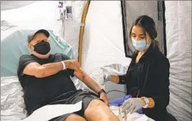  ?? Ana Ramirez San Diego Union-Tribune ?? MARK SWENSON, 71, gets his blood drawn by nurse Jessica Smith last week at Scripps Memorial Hospital Encinitas, which has opened an overf low tent.