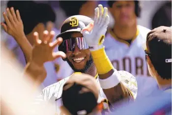  ?? GREGORY BULL AP ?? Jurickson Profar reacts with teammates in the dugout after hitting a two-run home run on April 20.