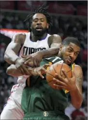  ?? MARK J. TERRILL — THE ASSOCIATED PRESS ?? Los Angeles Clippers center DeAndre Jordan, top, and Utah Jazz forward Derrick Favors go after a rebound during the second half in Game 7 of an NBA basketball first-round playoff series, Sunday in Los Angeles.