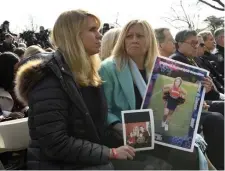  ?? AP ?? AMERICAN FAMILIES: Marla Wolff, left, and Susan Stevens hold photos of family members as they listen to President Trump on Friday. Several people who said they had lost family members to violence from illegal immigrants attended the event.