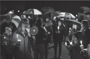  ?? JEFF WHEELER/MINNEAPOLI­S STAR TRIBUNE ?? Sherri Jasper, a Girl Scout board member and counselor at Halmstad Elementary School, leads the program for a candleligh­t vigil at the school in Chippewa Falls, Wis., on Sunday evening. The western Wisconsin community was grieving the deaths of three Girl Scouts and a parent who were collecting trash Saturday along a rural highway when police say a pickup truck veered off the road and hit them before speeding away.