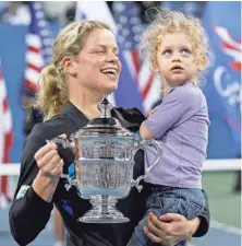  ?? MARK HUMPHREY, AP ?? Kim Clijsters holds daughter Jada after winning the 2010 U.S. Open, one of the three majors she won as a mom.