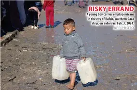  ?? AFP PHOTO ?? RISKY ERRAND A young boy carries empty jerricans in the city of Rafah, southern Gaza Strip, on Saturday, Feb. 3, 2024.