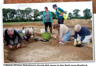  ??  ?? Labour of love: Volunteers brush dirt away in the field near Boxford