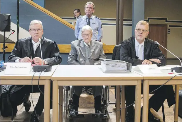  ?? BERND THISSEN / AFP / GETTY IMAGES ?? Former SS officer Reinhold Hanning, centre, sits next to his lawyers at a court in Detmold, Germany, on Friday. More than 70 years after the Second World War, Hanning was sentenced to five years’ imprisonme­nt over his role at the Auschwitz death camp...