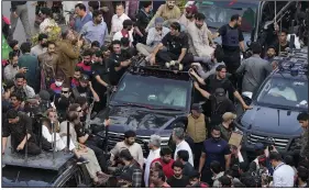  ?? (AP/K.M. Chaudary) ?? Security personnel and supporters move with a vehicle (center) carrying Pakistan’s former prime minister, Imran Khan, during an election campaign rally Monday in Lahore, Pakistan. More photos at arkansason­line.com/314pakista­n/.