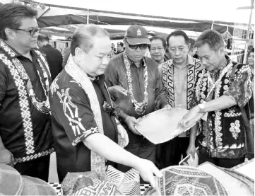  ??  ?? Rubin (second left) together with Ellron (left), Sairin (third left) and Ghani (second right) looking at handicraft made by the Murut community exhibited during the festival.