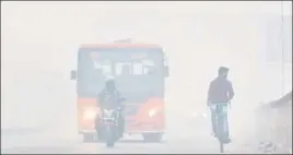  ?? SANCHIT KHANNA/HT PHOTO ?? (Above) Vehicles ply in heavy fog engulfed in New Delhi’s Patel Nagar on Monday; (below) Wreckage of the school bus that collided with a truck in Mainpuri on Monday. Ten school children from Baba Internatio­nal school were injured in the collision.