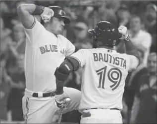  ?? RICHARD LAUTENS, TORONTO STAR ?? Blue Jays third baseman Josh Donaldson celebrates his first inning, two-run homer with teammate Jose Bautista. It was the first game of a three-game series between the teams vying for the two AL wild-card positions.