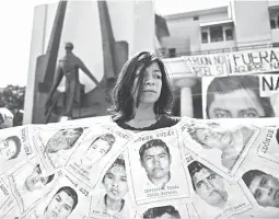  ??  ?? MISSING MEXICAN STUDENTS — A woman holds posters showing portraits of the 43 missing Mexican students from Ayotzinapa High School during a protest march held by members of the State Coordinato­r of Education employees and classmates of the missing...