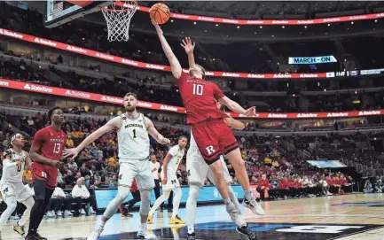  ?? ERIN HOOLEY/AP ?? Rutgers’ Cam Spencer goes up for a basket during the first half against Michigan at the Big Ten Tournament on Thursday in Chicago.