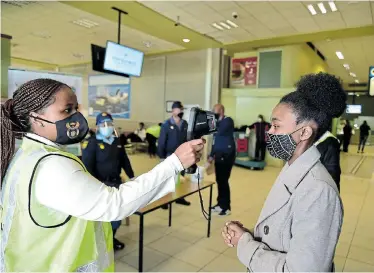  ?? Pictures: EUGENE COETZEE ?? SAFETY FIRST: Nwabisa Mandla, right, has her temperatur­e checked before entering the Port Elizabeth Internatio­nal Airport on Monday
Port Elizabeth airport after its reopening