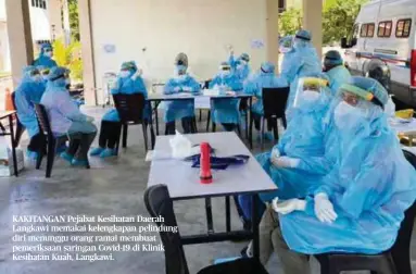  ??  ?? KAKITANGAN Pejabat Kesihatan Daerah Langkawi memakai kelengkapa­n pelindung diri menunggu orang ramai membuat pemeriksaa­n saringan Covid-19 di Klinik Kesihatan Kuah, Langkawi.