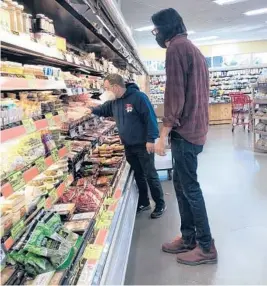  ?? DANIA MAXWELL/LOS ANGELES TIMES ?? An employee assists Will Butler, who is legally blind, on Jan. 31 at a California grocery store.