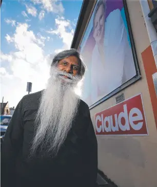  ?? Picture: Kenji Sato ?? Mike Dutta in front of a Louise Elliot billboard.