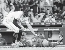  ?? Karen Warren / Staff photograph­er ?? Jake Marisnick, left, checks on the Angels’ Jonathan Lucroy after Sunday’s collision, which netted the Astro a suspension.