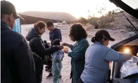  ?? Photograph: Go Nakamura/Reuters ?? Migrants receive food from volunteers in Jacumba Hot Springs, California, on 11 November.
