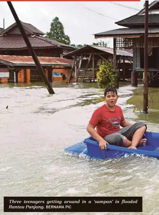  ?? BERNAMA PIC ?? Three teenagers getting around in a ‘sampan’ in flooded Rantau Panjang.