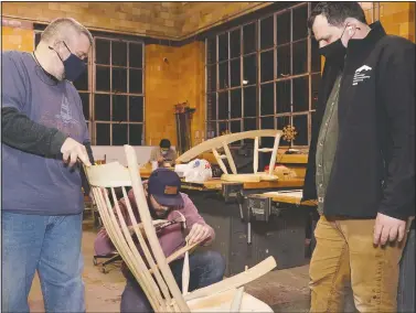  ?? (The Daily Telegram/Mike Dickie) ?? Jeff Rawlings (left) steadies a chair made by Caleb Peper (center) while Luke Barnett, director of the Sam Beauford Woodworkin­g Institute, looks on at the shop in Adrian, Mich. Rawlings and Peper are students in the Furniture Making and Wood Design class at the institute.