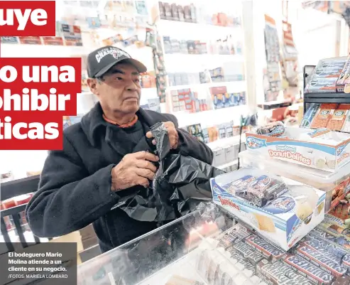  ?? /FOTOS: MARIELA LOMBARD ?? El bodeguero Mario Molina atiende a un cliente en su negocio.