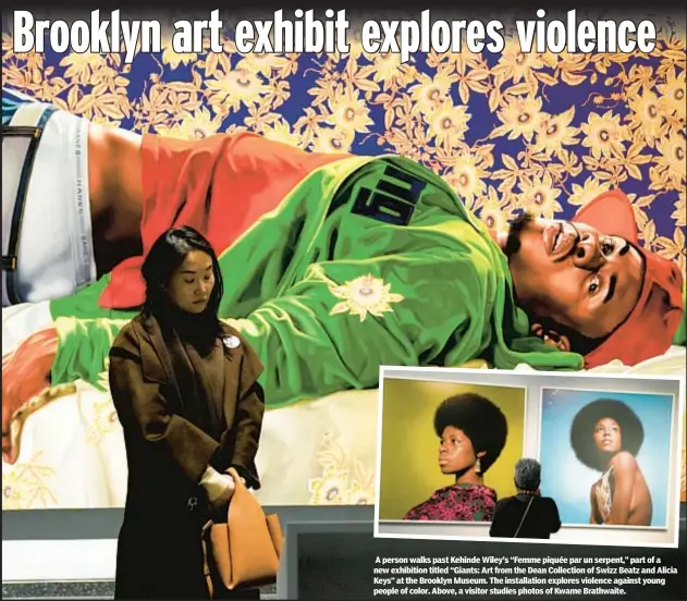  ?? ?? A person walks past Kehinde Wiley’s “Femme piquée par un serpent,” part of a new exhibition titled “Giants: Art from the Dean Collection of Swizz Beatz and Alicia Keys” at the Brooklyn Museum. The installati­on explores violence against young people of color. Above, a visitor studies photos of Kwame Brathwaite.