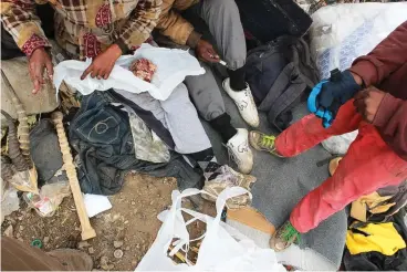  ?? Photo: Phillip Nyalungu ?? A couple wraps up some meat they found among the waste, while a teenager looks on. This is everyday life for pickers at the Grahamstow­n municipal landfill on the western edge of the town, Cradock road Saturday 12 August 2017.