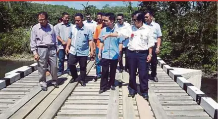  ?? FILE PIC ?? Tan Sri Joseph Kurup ( front, right) inspecting a bridge with Kampung Alab Lanas residents in Sook in 2016.