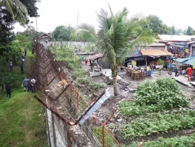  ?? —AFP ?? DARING ESCAPE Officials inspect the perimeter fence of the North Cotabato District Jail in Kidapawan City after members of the Bangsamoro Islamic Freedom Fighters raided the facility. Six people were reported killed in the daring jailbreak.