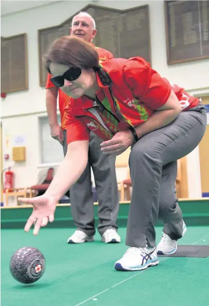  ?? JONATHAN MYERS ?? Blind bowler Julie Thomas in action, with her coach John Wilson