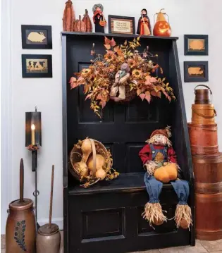  ??  ?? A bench made from an old door enlivens a corner of the kitchen and offers a place to decorate for the seasons. For autumn, it’s dressed with a combinatio­n of Halloween and fall flourishes.