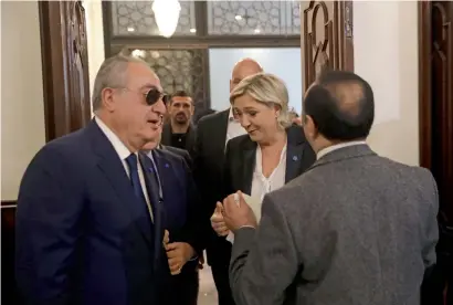  ?? AFP ?? An aide of Lebanon’s Grand Mufti Sheikh Abdel Latif Derian (right) holds a headscarf as he tries to convince Marine Le Pen to wear it during her meeting with the Mufti at Dar Al Fatwa, the headquarte­rs of the Mufti, in Beirut, Lebanon. —