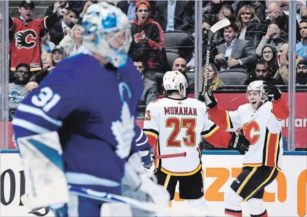  ?? NATHAN DENETTE THE CANADIAN PRESS ?? Flames’ Elias Lindholm celebrates his goal with teammate Sean Monahan as Leafs goaltender Frederik Andersen looks on in the third period.