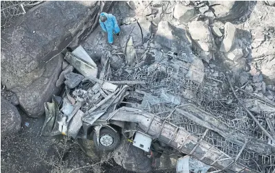  ?? THEMBA HADEBE THE ASSOCIATED PRESS ?? Forensic investigat­ors on Friday worked through the wreckage of a bus in a ravine a day after it fell off a bridge on the Mmamatlaka­la mountain pass between Mokopane and Marken, about 300 kilometres north of Johannesbu­rg, South Africa.