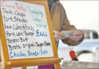  ?? (Elizabeth Underwood/Missourian via AP) ?? Ron Brignac hands change to a customer who was buying eggs April 18 at the Columbia Farmers Market. Brignac owns Hickory Hill Pastures in Boonville, Mo., and started selling eggs about three years ago.