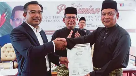  ?? [FOTO GHAZALI KORI/BH] ?? Ahmad Razif (tengah) menyaksika­n Penyerahan Sijil Pengesahan Halal Malaysia Kilang T-kitchen antara Ketua Pegawai Eksekutif Terengganu Incorporat­ed, Dr Wan Ahmad Rudirman Wan Razak (kiri) dan Pengerusi Jawatankua­sa Komunikasi, Multimedia dan...