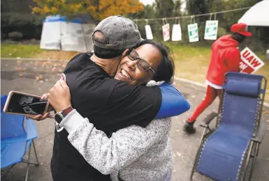  ?? Photos by Matt Rourke / Associated Press ?? Workers Richard Rivera and Robin Pinkney react to the tentative agreement with General Motors in Langhorne, Pa. The strike is still on for the moment, though, which is why Ryan Piper continues to picket, below.