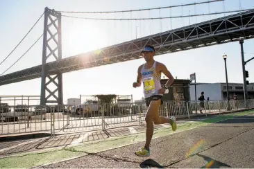  ?? Photos by Michael Short / Special to The Chronicle ?? Jorge Maravilla passes under the Bay Bridge on his way to winning the 2017 San Francisco Marathon.