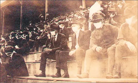  ??  ?? This undated photo provided by Georgia Tech alumnus Andy McNeil shows a Georgia Tech home game during the 1918 college football season. The photo was taken by Georgia Tech student Thomas Carter, who would receive a degree in Mechanical Engineerin­g. The 102-year-old photo could provide a snapshot of sports once live games resume: Fans packed in a campus stadium
in the midst of a pandemic wearing masks with a smidge of social distance between them on concrete seats. (AP)