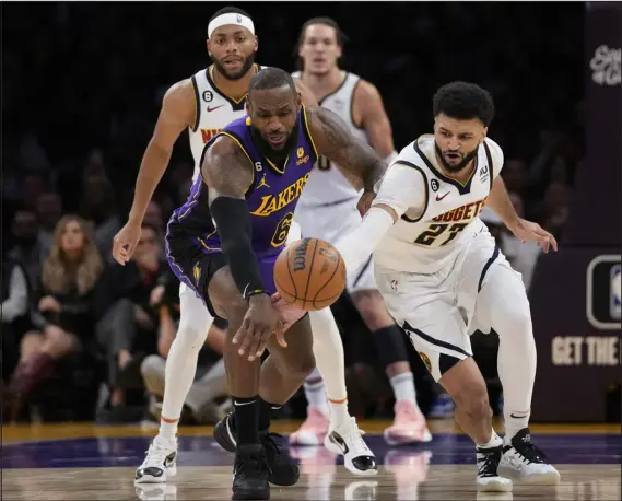 ?? ASHLEY LANDIS — THE ASSOCIATED PRESS ?? Los Angeles Lakers forward Lebron James and Nuggets guard Jamal Murray reach for a loose ball during a game in Los Angeles on Dec. 16.
