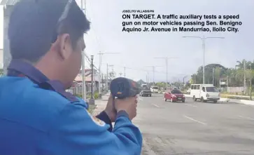  ?? JOSELITO VILLASIS/PN ?? ON TARGET. A traffic auxiliary tests a speed gun on motor vehicles passing Sen. Benigno Aquino Jr. Avenue in Mandurriao, Iloilo City.