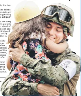  ??  ?? A girl hugs a Mexican marine officer as she offers hugs to people near the site of a collapsed building after the earthquake, in Mexico City. — Reuters photo