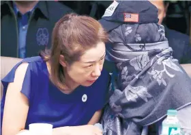  ??  ?? SENATE HEARING. Choi Kyung-jin, left, widow of South Korean businessma­n Jee Ick-joo, who was kidnapped and later killed by his abductors, and their former househelp Marissa Morquicho, confer at the start of the Senate investigat­ion on the killing. /AP...